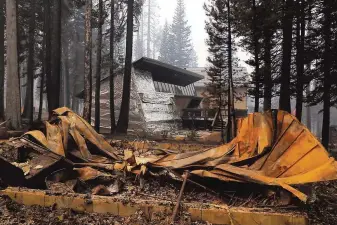  ?? Carlos Avila Gonzalez / The Chronicle ?? A home survived the flames after it was wrapped in foil as other structures nearby were destroyed in a residentia­l area near Sierra-at-Tahoe in the devastatio­n left by the Caldor Fire.