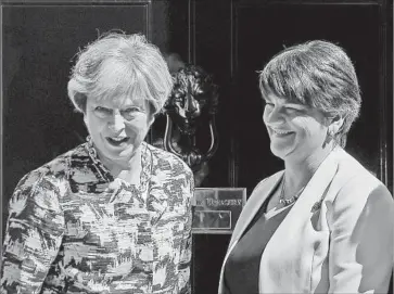  ?? Daniel Leal-Olivas AFP/Getty Images ?? THERESA MAY, left, with Arlene Foster, head of Northern Ireland’s Democratic Unionist Party, which agreed to back May’s minority government in return for nearly $1.3 billion in additional funding for her region.