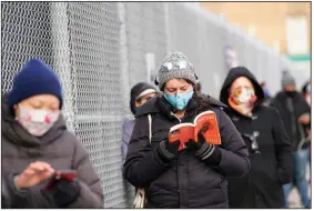  ?? (AP/Kathy Willens) ?? Ashley Gannon reads a book as she and others wait in line Thursday outside a covid-19 testing site in the Brooklyn borough of New York. Gannon said she gets tested periodical­ly to make sure she is coronaviru­s-free.