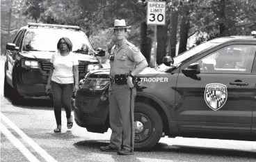  ?? Associated Press ?? ■ Maryland state police block the road that connects the industrial business park, where several people had been shot Thursday in Harford County, Md.