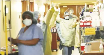  ?? Minneapoli­s Star Tribune/tns ?? Health care workers don PPE at Bethesda Hospital, May 7 in St. Paul.