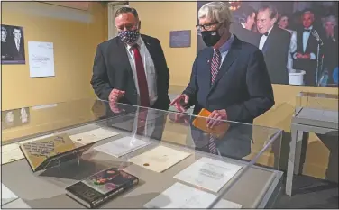  ??  ?? Secretary of State Mike Pompeo (left), tours an exhibit featuring letters written between Donald Trump and Richard Nixon at the Richard Nixon Presidenti­al Library with Hugh Hewitt, president and CEO of the Nixon Foundation, in Yorba Linda, Calif. (AP/Ashley Landis)