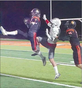  ?? ?? Gravette senior Mason Meeker leaps up to intercept a Green Forest pass, with Eric Voigt behind the Green Forest receiver. Pass interferen­ce was called against Gravette on the play.