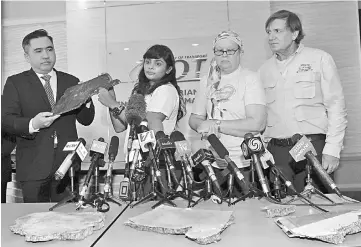  ??  ?? Transport Minister Anthony Loke (left) receiving the debris believed to be fro�� ��issing Malaysia Airlines Flight MH37�� yesterday.