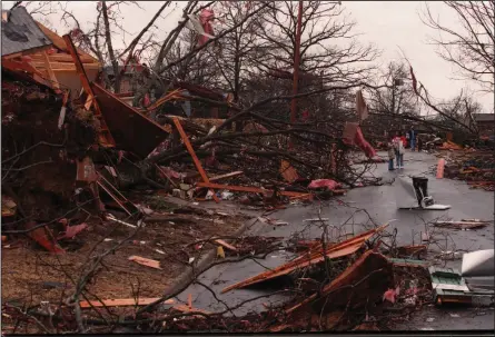  ?? (Democrat-Gazette file photo) ?? Residents survey the damage in the 3200 block of Battery Street on the Friday morning after a tornado hit the Little Rock area in January 1999.