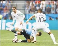  ?? David Vincent / Associated Press ?? France’s Antoine Griezmann, left, runs with the ball during a quarterfin­al match against Uruguay at the World Cup on Friday.