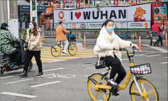  ?? ?? NORMALIDAD. Personas cruzan una calle en Wuhan, en la provincia central de Hubei previo a Año Nuevo.