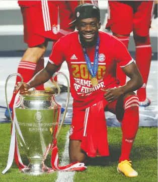  ?? MIGUEL A. LOPES/ VIA REUTERS ?? Canadian Alphonso Davies celebrates winning the Champions League trophy with Bayern Munich earlier this year. He's hoping to return to the pitch soon after suffering an ankle injury.