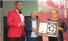  ?? Picture: Tinashe Chitwanga ?? Sunday Mail Editor Victoria Ruzvidzo, accompanie­d by her son Wayne Ruzvidzo (left), receives the Super Platinum Award in Profession­al Excellence from Mashwede Holdings owner Mr Alex Mashamhand­a at the Zimbabwe CEO’s Network awards ceremony in Harare last week. —