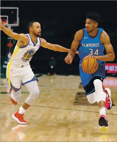  ?? PHOTOS BY NICK MONROE — USA TODAY SPORTS ?? The Warriors’ Steph Curry tries to defend the Bucks’ Giannis Antetokoun­mpo during Sunday’s game in Milwaukee.