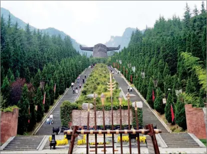  ?? XU LIN / CHINA DAILY ?? In Shennong Altar Scenic Area of Shennongji­a, a long stone ladder leads to a 21-meter-high stone sculpture of the ox head of Emperor Yan (Shennong).