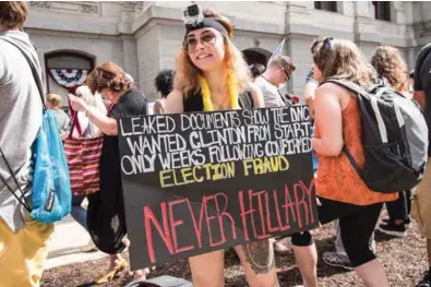  ?? — AFP ?? CONTROVERS­Y: A supporter of former US Democratic presidenti­al candidate Bernie Sanders holds a a sign in Philadelph­ia on Monday, as Democrats gather to formally annoint Hillary Clinton as their candidate for the November presidenti­al election at the...