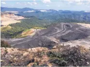  ?? MICHAEL VIRTANEN/ASSOCIATED PRESS ?? Coal trucks and heavy equipment look like children’s toys on the Middle Ridge surface coal mine, which cut off part of Coal River Mountain in southern West Virginia.