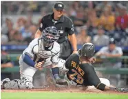  ?? USA TODAY SPORTS ?? Pirates rightfield­er Gregory Polanco slides past Milwaukee Brewers catcher Manny Pina to score a run.