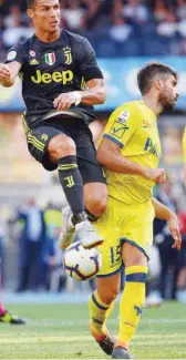  ??  ?? From left: Juventus’ Cristiano Ronaldo (left) and Chievo’s defender Michele Rigione go for the ball during their Italian League match at the Marcantoni­o-bentegodi Stadium in Verona on Saturday. Juventus’ Sami Khedira (second right) celebrates with team-mates after scoring against Chievo.