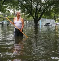  ?? (Ap/miami Herald/sam Navarro) ?? Mario Leiva, 75, uses a stick in an attempt to unblock the sewer drainage on a street in Miami’s Little Havana on Saturday.