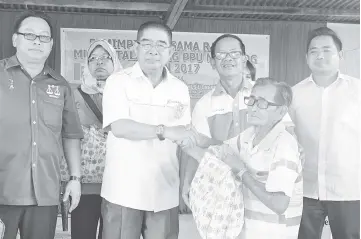  ??  ?? Maximus presenting assistance to one of the recipients during the meet-the-people session for Mukim Talantang in Kota Marudu.