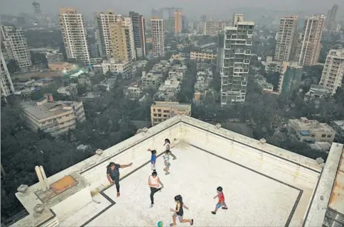  ?? HEMANSHI KAMANI / HT ?? MUMBAI
■
(above): You have to watch how hard you kick the ball, when there’s a chance it could plummet several stories. But the terrace and building lobby are often the only spaces available for play in overcrowde­d Mumbai. “I get so bored. We just go...
