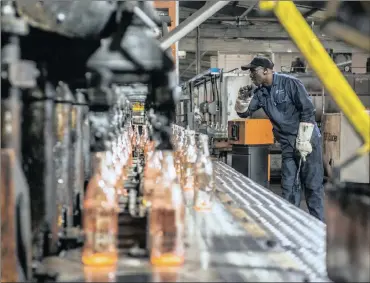  ?? PHOTO: BLOOMBERG ?? Clear glass bottles cool after moulding at the Nampak manufactur­ing plant in Roodekop. The company said yesterday it was still battling to transfer money from Nigeria and Angola to South Africa.