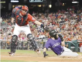  ?? —AFP ?? WASHINGTON: Matt Wieters #32 of the Washington Nationals tags out Charlie Blackmon #19 of the Colorado Rockies trying to advance on Gerardo Parra #8 (not pictured) single in the fifth inning during game two of a doublehead­er at Nationals Park on Sunday...