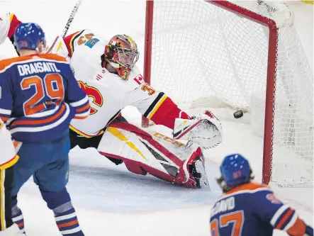  ?? GREG SOUTHAM ?? Calgary Flames goaltender David Rittich can’t stretch far enough to prevent Connor McDavid of the Edmonton Oilers scoring during Sunday’s Battle of Alberta at Rogers Place in Edmonton. It was to be game’s only goal in a 1-0 Oilers’ victory, snapping the Flames’ winning streak at five.