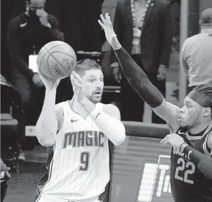  ?? PEDRONCELL­I/AP RICH ?? Magic center Nikola Vucevic, left, passes the ball as Kings center Richaun Holmes guards him Friday in Sacramento, Calif. He scored 42 points.