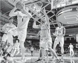  ?? AL DIAZ/AP ?? Miami guard Dejan Vasiljevic (1), who scored 21 points, looks to pass to center Ebuka Izundu (15) as Georgia Tech guard Jose Alvarado (10) defends on Saturday.