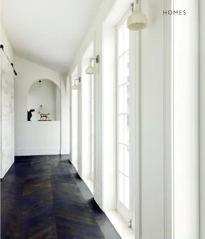  ??  ?? THIS PAGE The parquet flooring in the hallway is hand-laid using Lithuanian oak; the walls are painted Resene ‘Half Rice Cake’ and the lighting is by Kartell.
OPPOSITE The ceiling colour was existing; the velvet chair is an American vintage find, the...