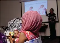  ??  ?? MILWAUKEE: Irena Bottoms feeds her baby as mothers and supportive family members attend a monthly gathering.