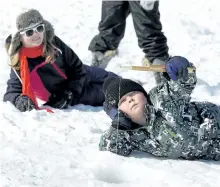 ?? CLIFFORD SKARSTEDT/EXAMINER FILES ?? Charlie Horton, 7, soaks up the sunny weather next to his sister Holly, 10, as they join hundreds of anglers enjoying a day of ice fishing on Chemong Lake next to the James A. Gifford Causeway on Feb. 15, 2014 during the Ontario Federation of Anglers...