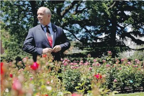  ?? CHAD HIPOLITO/THE CANADIAN PRESS ?? NDP Leader John Horgan buttons up his jacket after speaking to reporters at the legislatur­e rose garden on Monday. After his party, with the help of the Greens, defeated two bills Monday, Horgan said this session is “about testing the confidence of the...