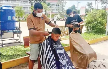  ?? SUPPLIED ?? Two students are getting their hair cut in a school-approved style at Hun Sen Khlaing Leu High School in Preah Sihanouk province last month.