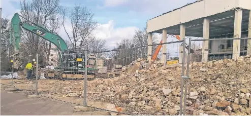  ?? RP-FOTO: HEIDE-INES WILLNER ?? Mit schwerem Gerät sind die Bauarbeite­r angerückt, um den Altbau zurückzuba­uen.