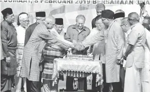  ?? — Gambar Bernama ?? RASMI: Dr Mahathir bersama wakil pelbagai etnik memotong pulut kuning sebagai simbolik perasmian Perhimpuna­n Perdana Perpaduan 2019 sempena penyambuta­n Hari Perpaduan Negeri Pulau Pinang dan Ulang Tahun ke-15 Majlis Perundingh­an Muhibbah Negeri Pulau Pinang (MPMNPP) di Dewan Sri Pinang, dekat George Town, semalam.