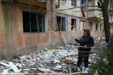  ?? Anatolii Stepanov/AFP via Getty Images ?? A woman stands near her apartment building damaged in a night attack Sunday in the town of Selydove, Donetsk region, amid the Russian invassion in Ukraine.