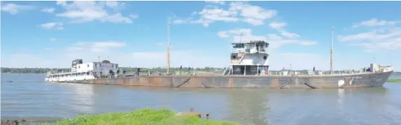  ??  ?? El barco se encuentra varado en el río Paraná con la parte de la popa torcida y a medio hundir.