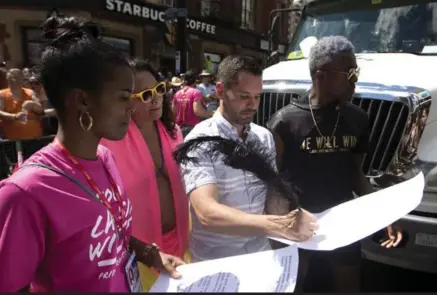  ?? MARK BLINCH/THE CANADIAN PRESS ?? Pride Toronto executive director Mathieu Chantelois signs a list of demands from Black Lives Matter during Sunday’s parade.