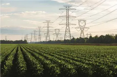  ?? TAMIR KALIFA/THE NEW YORK TIMES 2021 ?? Transmissi­on towers carry power lines over agricultur­al land in Fort Bend County, Texas.