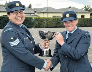  ?? PHOTO: NEW ZEALAND DEFENCE FORCE ?? Top marks . . . Aircraftma­n Sophie Aitken (right), of Queenstown, receives the Andrea McNabb Perseveran­ce Cup presented by Flight Sergeant Andrea McNabb after a recruit graduation ceremony at Base Woodbourne, near Blenheim.