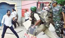  ?? FILE PHOTO ?? Security personnel chasing away a mob after the vehicle of TDP Chandragir­i MLA candidate Pulivarthi Nani was attacked on the SPMVV campus in Tirupati on May 14, a day after polling.