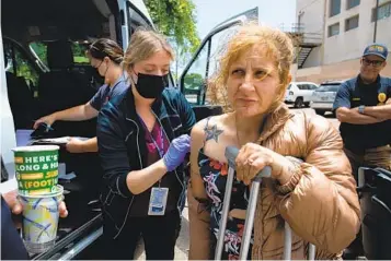  ?? ADRIANA HELDIZ U-T ?? Torrey Henry, a public health nurse with the San Diego County, disinfects Kristina Long’s arm before administer­ing a hepatitis A vaccinatio­n in downtown San Diego on Tuesday. Teams of health care workers are making the rounds more frequently offering vaccines.