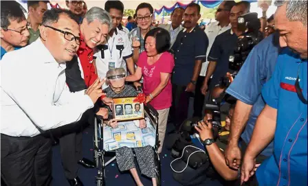  ?? — Bernama ?? Popular matriach: Dr Ahmad Zahid (on Leong’s right) presenting the framed pictures to Leong, which was kept by the NRD over the years, during the event at the Home Ministry complex in Ayer Keroh, Malacca as Chief Minister Datuk Seri Idris Haron (left)...