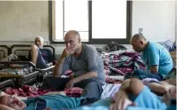  ?? AFP ?? Syrian patients sit in beds in a room at the mental health clinic in the town of Azaz, near the border with Turkey. —