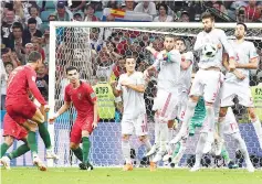  ??  ?? Portugal’s forward Cristiano Ronaldo (L) shoots to score his thrird goal during the Russia 2018 World Cup Group B football match between Portugal and Spain at the Fisht Stadium in Sochi on June 15, 2018.