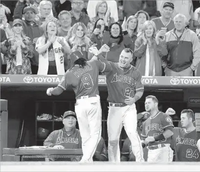  ?? Gina Ferazzi Los Angeles Times ?? MIKE TROUT is the first to greet Cameron Maybin after the left fielder hit his first home run for his new team in the sixth.