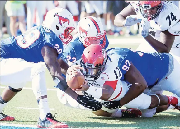  ??  ?? Cincinnati quarterbac­k Jarred Evans (12) stretches for a touchdown, as he is hit by SMU defensive back Darrion Richardson (left), defensive back Hayden Greenbauer (22) and defensive end Zelt Minor
(92), during the first half of an NCAA college...