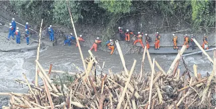  ?? KYODO ?? Japanese firefighte­rs search for flood survivors in Toho village, Fukuoka prefecture, yesterday.