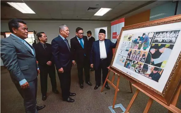  ?? PIX BY SAIRIEN NAFIS AND FARIZ ISWADI ISMAIL ?? Penang Yang di-Pertua Negeri Tun Abdul Rahman Abbas (right) taking a closer look at a souvenir photo presented during his visit to Balai Berita yesterday. With him are New Straits Times Press chairman Tan Sri Ismail Omar (third from left), NSTP chief executive officer Datuk Abdul Jalil Hamid (second from right), ‘Berita Harian’ group editor Datuk Mahfar Ali (second from left) and ‘Harian Metro’ group editor Datuk Mustapa Omar.