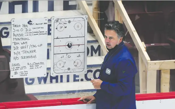  ?? NICK PROCAYLO ?? Canucks coach Travis Green works with his whiteboard­s on Monday during training camp at Rogers Arena. Sunday's practice was cancelled due to a false positive COVID test.