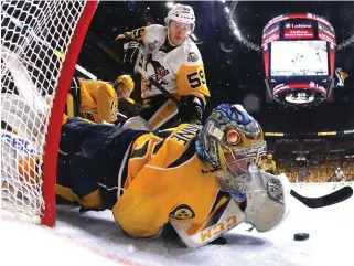  ??  ?? Pekka Rinne of the Nashville Predators makes a glove save against Jake Guentzel (59) of the Pittsburgh Penguins during the second period in Game 4 of the 2017 NHL Stanley Cup Final at the Bridgeston­e Arena on Tuesday in Nashville, Tennessee. (AFP)